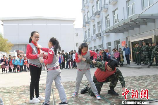 孩子们争相体验摔擒格斗技巧。　刘威 摄